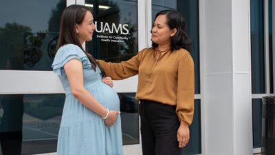 Doula speaking to a pregnant woman outside the UAMS Institute for Community Health Innovation