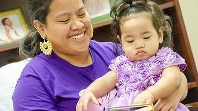 Marshallese mother reading to her baby