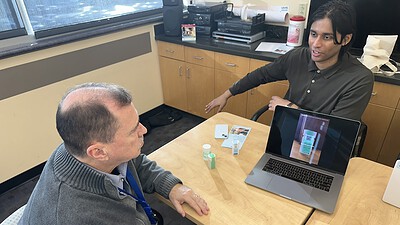 Sonara Health Business Operations Manager Kshitij Verma (right) demonstrates how to use the online repository to Jere Brewer of UAMS’ Center for Addiction Services and Treatment.