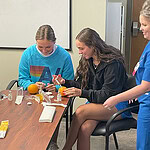 High school students practice injections using oranges