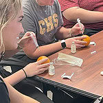 High school students practice injections using oranges