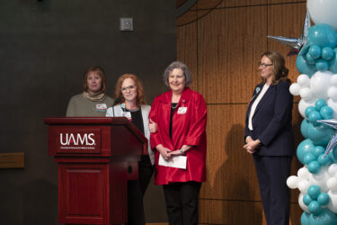 Tammy King-Jones (center left), UAMS chief nursing officer, and Mary Helen Forrest, a business operations consultant for inpatient care, react to the announcement. They’re joined by Michelle Krause (left), CEO of UAMS Medical Center, and Rebekah Thacker, nursing director of Research, Excellence and Magnet.