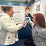 Robin Camp, RN (left), assisted by Belen Castres, the All of Us tour manager, said she was interested in joining the research program as soon as she heard about it.