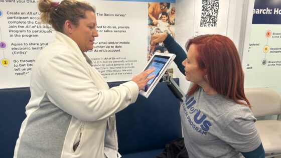 Robin Camp, RN (left), assisted by Belen Castres, the All of Us tour manager, said she was interested in joining the research program as soon as she heard about it.