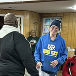 David Williams, left, and Reginald Williams, center, share a laugh with one of the veterans at St. Francis House who was receiving a gift bag from UAMS.