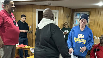 David Williams, left, and Reginald Williams, center, share a laugh with one of the veterans at St. Francis House who was receiving a gift bag from UAMS.