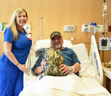 Gina Boshears, RN, on Nov. 11. gives a care package to Duel Going, a veteran and UAMS Medical Center patient,