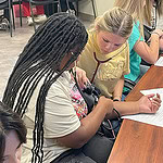 High school students practice taking blood pressure.