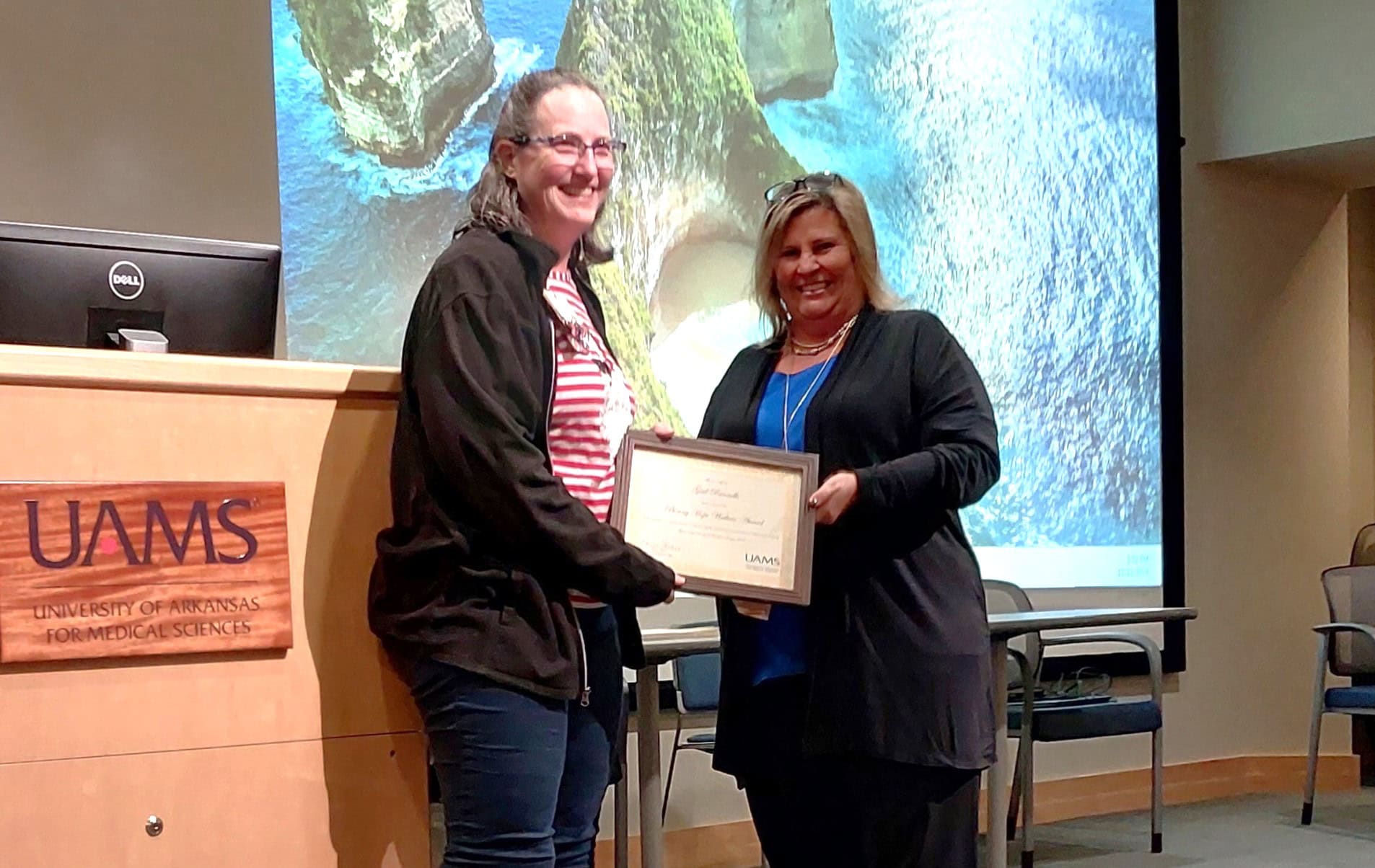 Gail Runnells, RN (left), receives the Bonny Hope Wallace Award from Jennifer McClusky, UAMS research compliance manager.