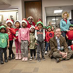 UAMS Chancellor Cam Patterson, M.D., MBA, poses with the carolers and their leaders for a photo.