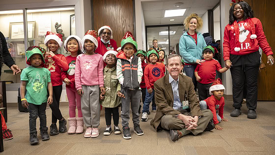 UAMS Chancellor Cam Patterson, M.D., MBA, poses with the carolers and their leaders for a photo.