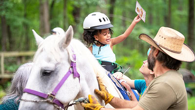 Therapists, volunteers and graduate students interact with a child in the UAMS hippotherapy program.