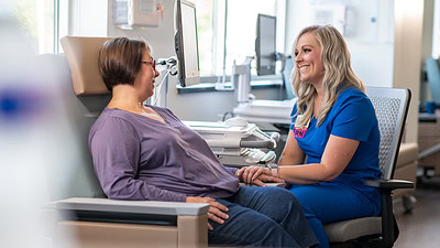 A nurse speaks to a cancer patient in the hospital