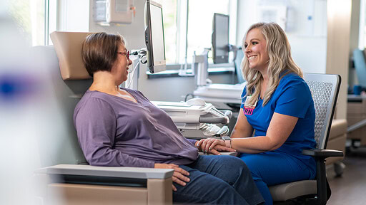 A nurse speaks to a cancer patient in the hospital