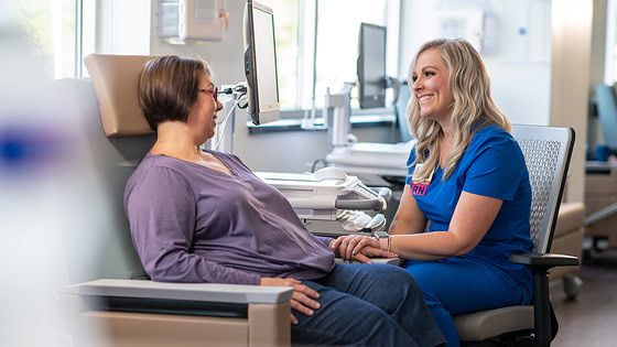 A nurse speaks to a cancer patient in the hospital