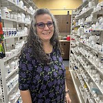 Michelle Duncan, a community health worker, poses in a rural pharmacy.