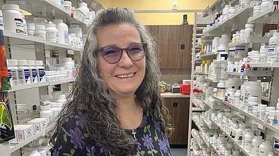 Michelle Duncan, a community health worker, poses in a rural pharmacy.