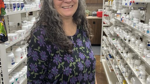 Michelle Duncan, a community health worker, poses in a rural pharmacy.