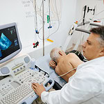 Stock image of a doctor viewing an echocardiogram image on a computer screen.