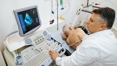 Stock image of a doctor viewing an echocardiogram image on a computer screen.