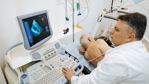 Stock image of a doctor viewing an echocardiogram image on a computer screen.