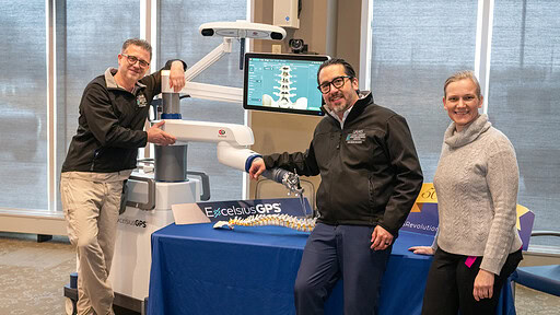 UAMS neurosurgeons, from left, Viktor Palys, M.D., Hector Soriano-Baron, M.D., and Erika Petersen, M.D., pose with the Excelsius GPS robot.