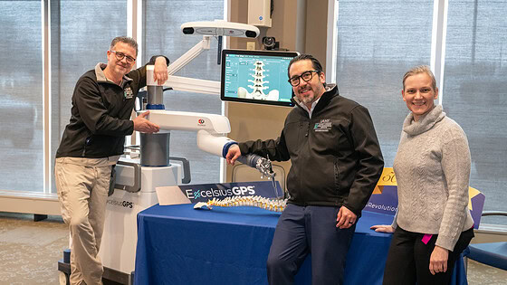 UAMS neurosurgeons, from left, Viktor Palys, M.D., Hector Soriano-Baron, M.D., and Erika Petersen, M.D., pose with the Excelsius GPS robot.