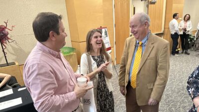 Lizzy East Couch and her husband, Patrick (left), share a laugh with UAMS neurologist R. Lee Archer, M.D., before the start of the symposium.