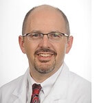 portrait photo of Simon Mears with UAMS logo
