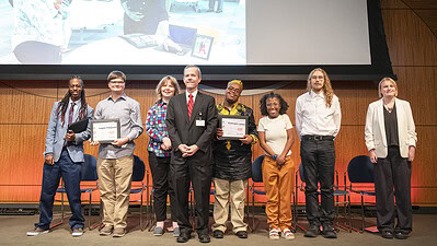 Seven members of the Project SEARCH Class of 2025 participated in the May 15 graduation ceremony. Chancellor Cam Patterson, center, delivered opening remarks. Project SEARCH graduates, left to right, are: Tyheim Bones, Logan Ferguson, Amy Johnson, Keshawn Lamar, Lacinda Carter, Gavin McGinnis and Sunny Welch. Not pictured, Layla Macon.