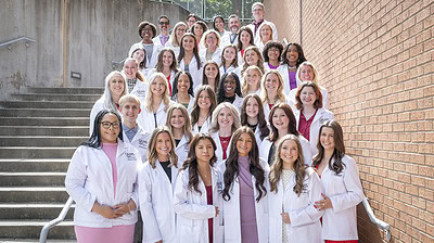 Along with faculty, students in the audiology and speech-language pathology programs gather for a photo after the white coat ceremony.