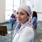 Portrait of cancer survivor with support group in background