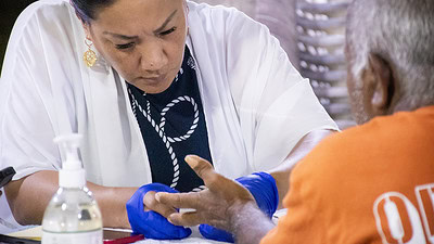 A UAMS health care workers conducts a blood test on a Marshallese patient.