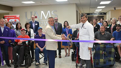 Cal Brooks, regional vice president of the ALS Association, and Rohit Dhall, professor and the chair of the UAMS Department of Neurology, cut the ribbon at the new UAMS Northwest ALS Clinic in Fayetteville.