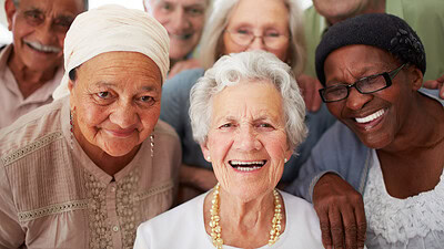 A group of seniors smiling together while in a retirement home