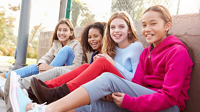 Four adolescent girls sitting in row and smiling