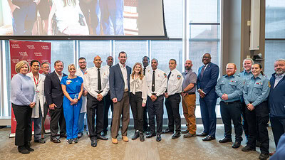 Katie McClanahan (center) and her husband thanked the UAMS Trauma Team, Trauma Team, Metropolitan Emergency Medical Services (MEMS) and the Little Rock Fire Department for saving her life.