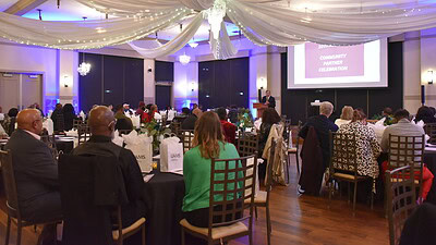 wide-angle shot of dining hall as the celebration opens with C. Lowry Barnes, M.D., interim UAMS chancellor, addressing the crowd from the front of the room.