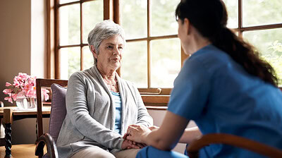 This stock-art photo shows a young nurse holding hands with an elderly woman in a retirement home.