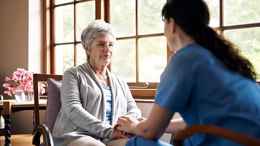 This stock-art photo shows a young nurse holding hands with an elderly woman in a retirement home.