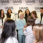 Students gather around an attendee at the scholarship reception. The UAMS College of Nursing held the Feb. 26 reception at the Northwest Regional Campus in Fayetteville to award $2,000 in scholarships to every member of the accelerated Bachelor of Science in Nursing program.