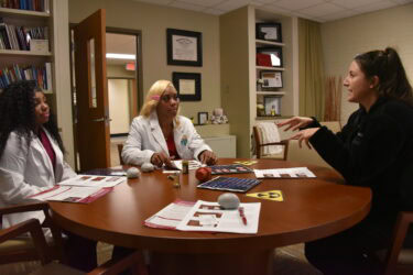 Summer Khairi (right), Ph.D., talks to Hall High students about UAMS’ Nuclear Medicine Imaging Sciences Program. The small-group format gave students more time to meet with health professionals and ask in-depth questions.