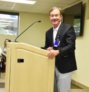 Barnes at lecturn, smiling