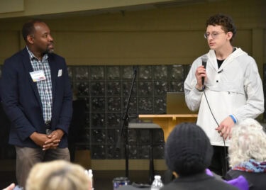 An attendee offers some words of inspiration for his fellow survivors as Charlie Simpson, a therapist at the Arkansas Relationship Counseling Center, looks on.