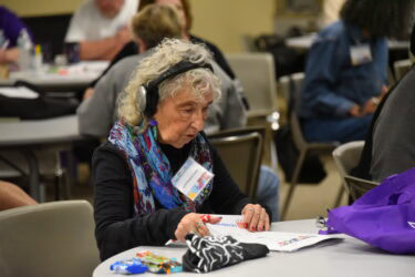 Leyah Bergman Lanier takes part in an activity while seated at a table during Arkansas Brain Injury Survivors’ Day.