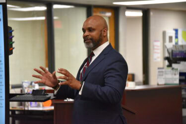 Carlton McGee, principal of Hall High, stands in front of a lectern during his speech at the ceremony.