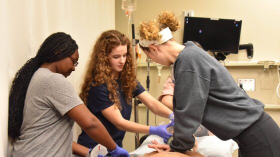 Andersyn Van Kuren, a 10th grader at Parkview Arts and Science Magnet High School in Little Rock, performs chest compressions on a manikin during a trauma-care simulation in the UAMS Simulation Center.