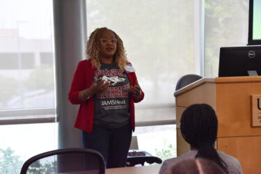 Sharanda Williams, assistant dean for student affairs in the College of Medicine, stands in front of a seated student during a presentation about the college’s admissions process.