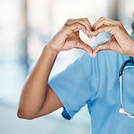 Smiling nursing making a heart gesture with her hands.
