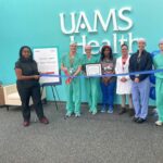 photo of Dr. Brian Langford preparing to cut ribbon, in a line with seven other people.